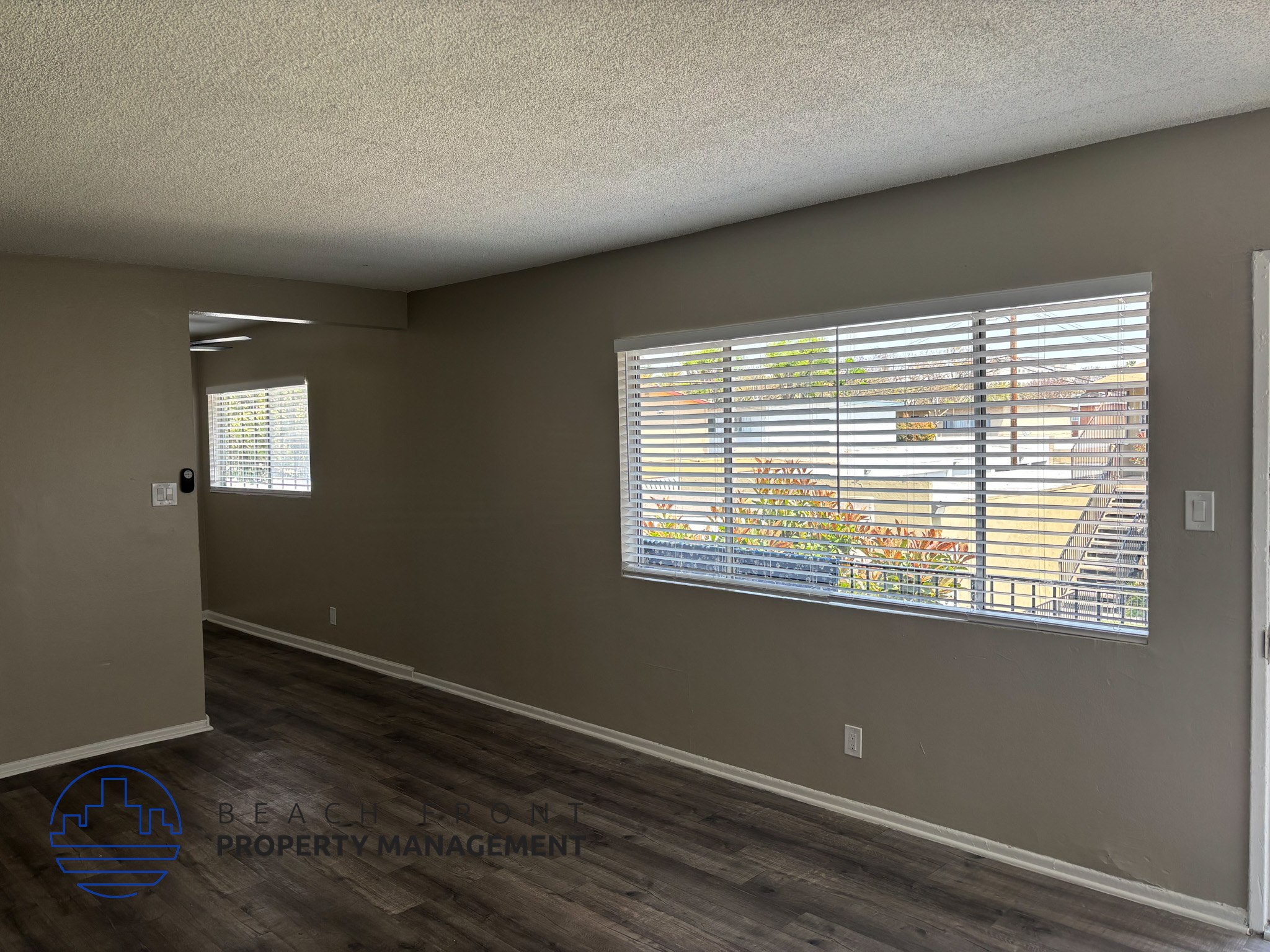 , A room with a window showing a view of a building and trees.,A room with a window showing a view of a building and trees.